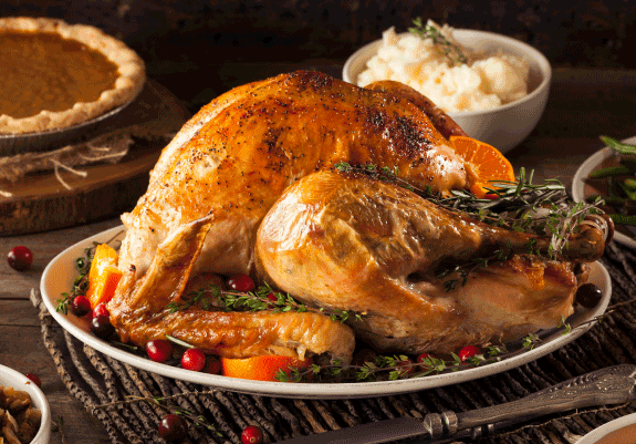 Side view of roasted turkey on set table with side dishes