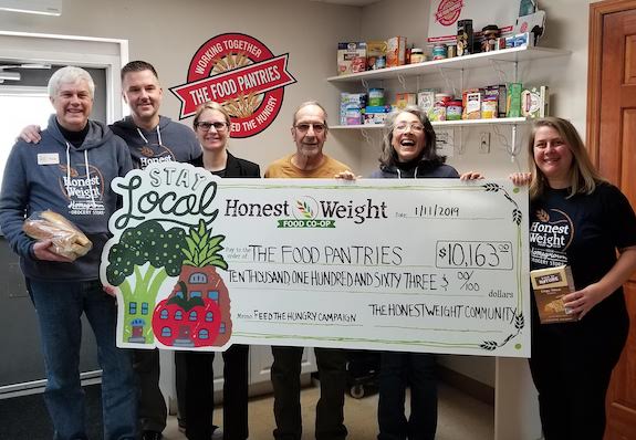 Honest Weight and The Food Pantries staff with giant check