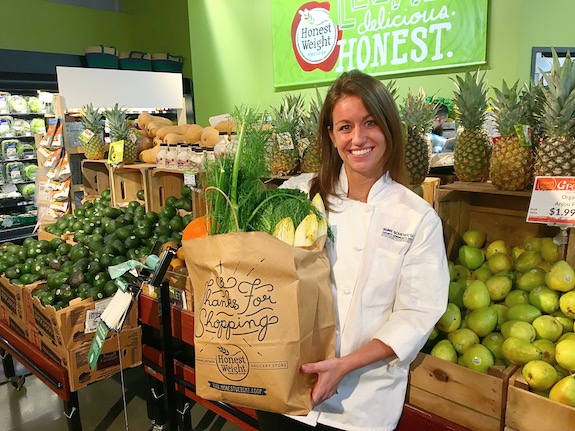 Chef Courtney with an Honest Weight paper bag full of food