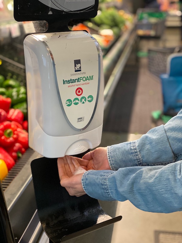 hands using a sanitizing station at HWFC