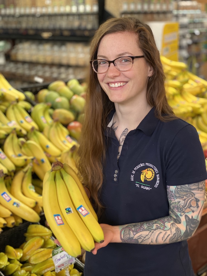 Photo of Kate Glenn in front of an Equal Exchange banana display at HWFC